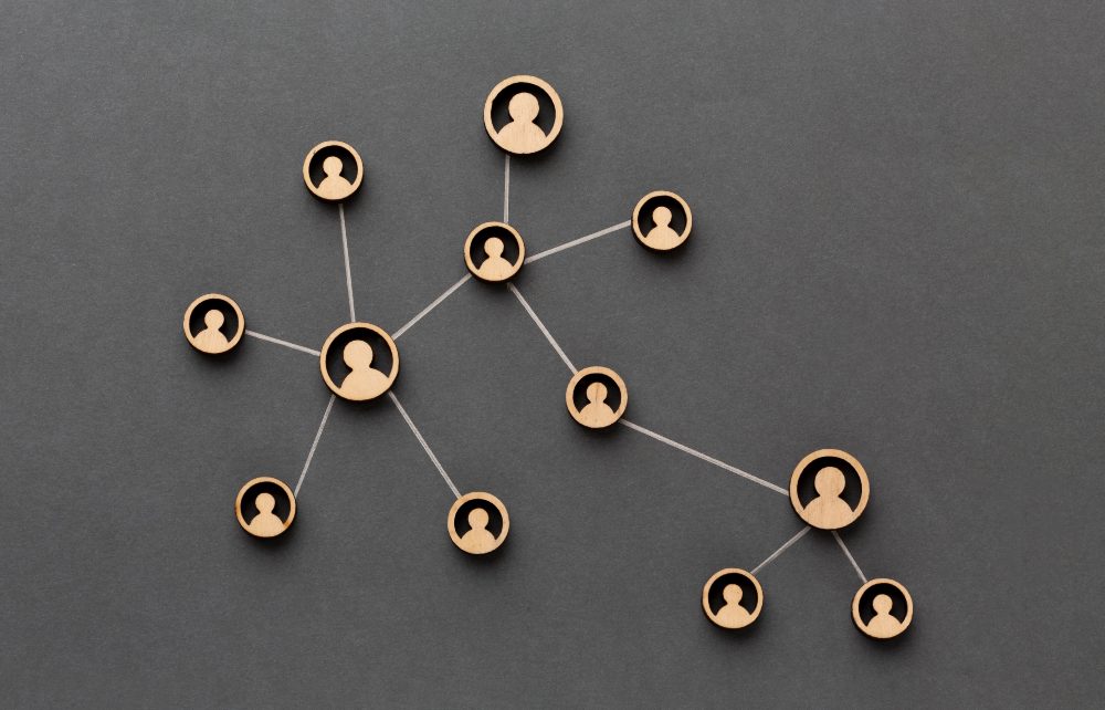 A group of individuals interconnected by a network of wooden figures, symbolizing unity and collaboration.